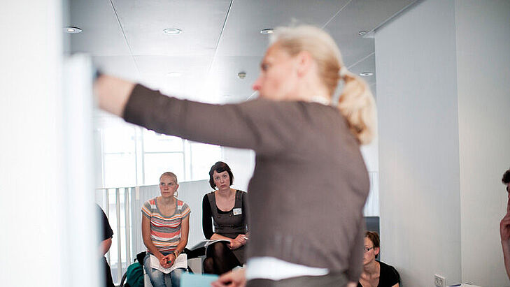 Moderatorin neben Stellwand